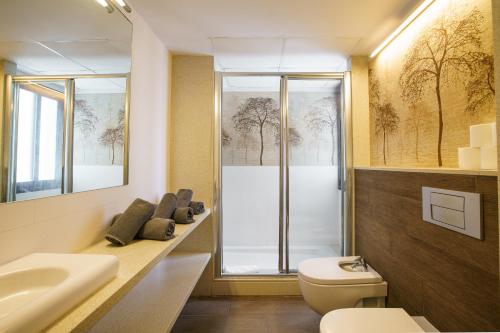 a bathroom with a toilet and a sink and a mirror at Apartamentos San Francisco in San Antonio