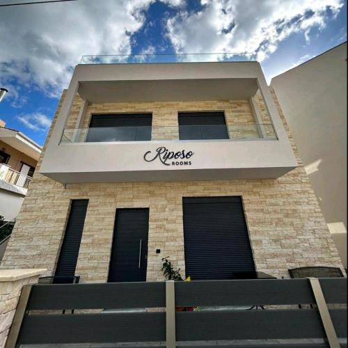a building with a sign on the side of it at RiposoRooms in Nafpaktos