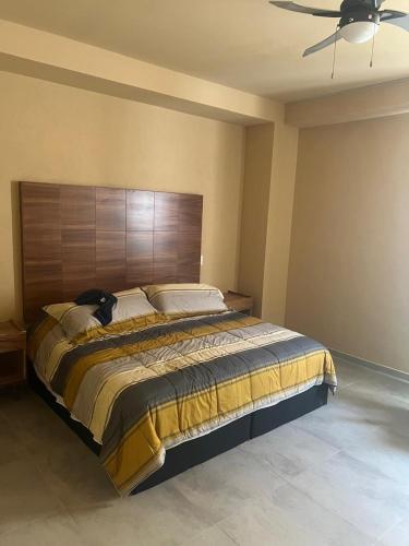 a bedroom with a large bed with a wooden headboard at Mangle09 in Puerto Vallarta
