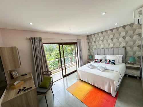 a bedroom with a large white bed and a window at Dos Lunas Aparthotel in J. E. Estigarribia