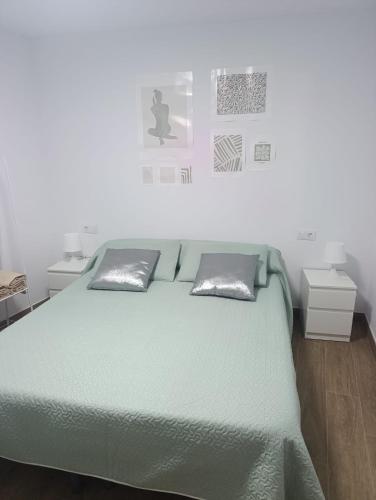 a bedroom with a green bed with two pillows at Casa rural El Terreno in Teruel