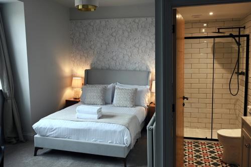 a bedroom with a white bed and a shower at Royal Lion Hotel in Tenby