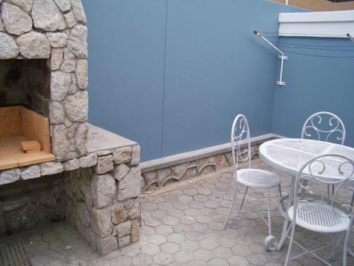 a patio with a table and chairs next to a stone fireplace at Jetty Self-Catering in Swakopmund