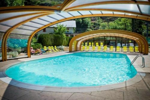a large swimming pool with an arbor and an outdoor swimming poolvisor at ZEcamping 4 étoiles avec restaurant et animations Alpe dHuez in Le Bourg-dʼOisans