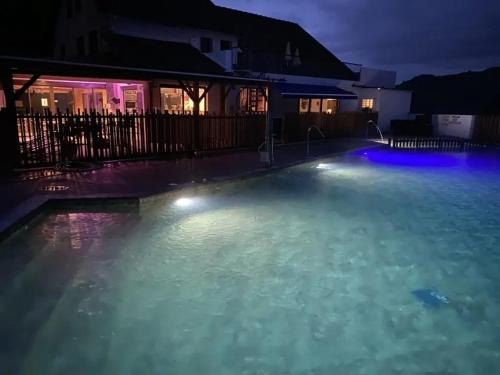 a swimming pool at night with blue lights at ZEcamping 4 étoiles animaux acceptés tennis piscine couverte in Vic-sur-Cère