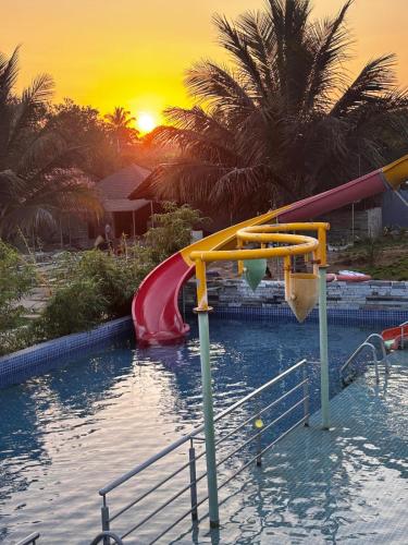 a swimming pool with a slide in the water at Nature's Resort in Kaivār