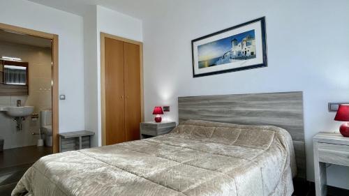 a bedroom with a large bed and a sink at Apartament DARSENA B 2-2 in L'Estartit