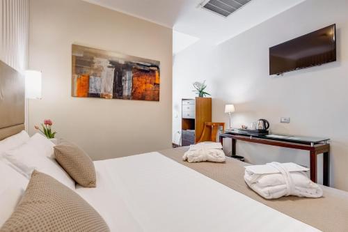 a bedroom with a white bed and a desk at Best Western Hotel Piccadilly in Rome