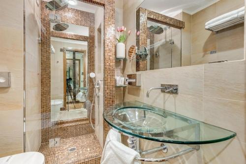 a bathroom with a glass sink and a shower at Best Western Hotel Piccadilly in Rome