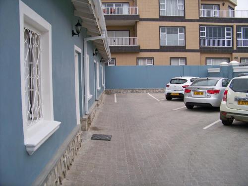 a parking lot with cars parked next to a building at Jetty Self-Catering in Swakopmund
