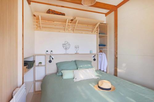 une chambre avec un lit sur lequel il y a un chapeau dans l'établissement Camping - Piscine - ccbbdag, à Vic-sur-Cère
