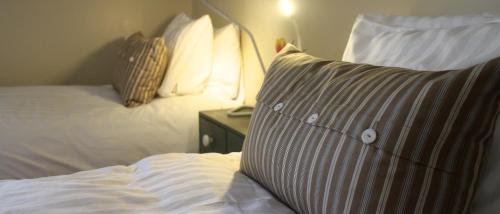 a bedroom with a bed with pillows and a night stand at Knappgården in Särna