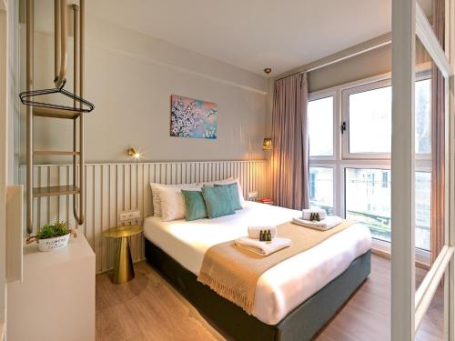 a hotel room with a large bed and a window at Karitsi Suites in Athens