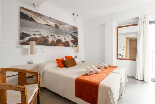 two beds in a room with white walls at Hotel Florencio Ibiza in San Antonio