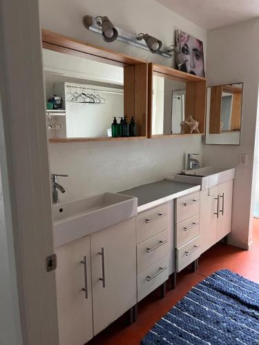 a bathroom with two sinks and a mirror at Ocean Front Vortex Female Hostel private rooms Free bikes in Los Angeles