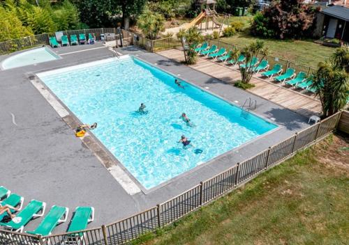 a group of people swimming in a swimming pool at Camping La Clairière - Aquatique Vacances in Saint-Paul-en-Born