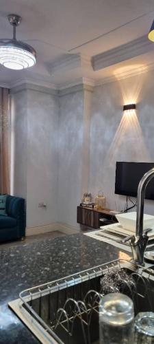 a kitchen with a sink and a living room at Legacy Homes in Dar es Salaam