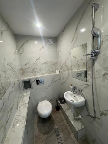 a white bathroom with a sink and a toilet at Berta Gardens 2 in Sandanski