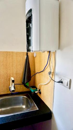 a kitchen counter with a sink and a phone at Indran in Chhatikara