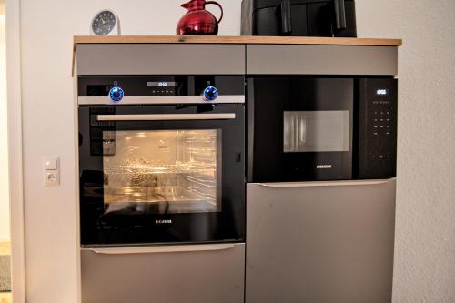a kitchen with an oven and a microwave at Gästewohnung Schöningen in Schöningen