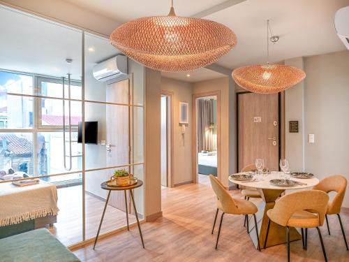 a living room with a table and chairs and two lights at Karitsi Suites in Athens