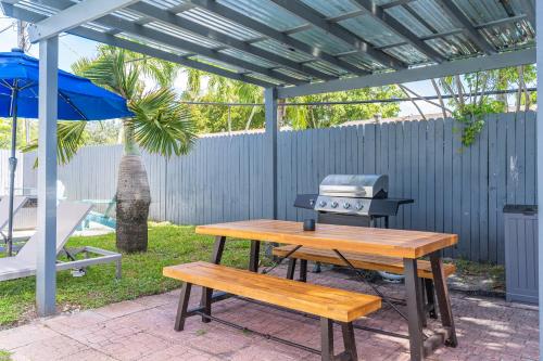 a picnic table with a grill and two benches at Hollywood Villa Luxury & Private Pool in Hollywood
