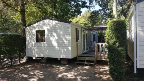 a white tiny house sitting next to a house at ZEcamping 5 étoiles avec piscine chauffée dog friendly sauna tennis 3km plage in Vieux-Boucau-les-Bains