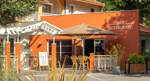 an orange restaurant with chairs and umbrellas in front of it at ZEcamping 5 étoiles avec piscine chauffée dog friendly sauna tennis 3km plage in Vieux-Boucau-les-Bains