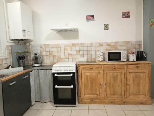 una cucina con fornelli e forno a microonde di Le Patio a Villegailhenc