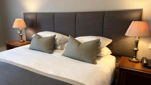a bed with two pillows on it with two lamps at Meadowlands Hotel in Tralee