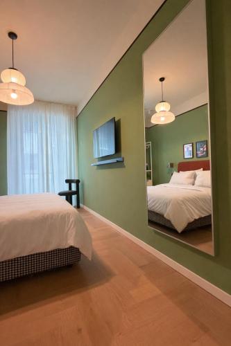 a bedroom with two beds and a large mirror at Suite Cecilia by Piazza del Lago, Como Center in Como