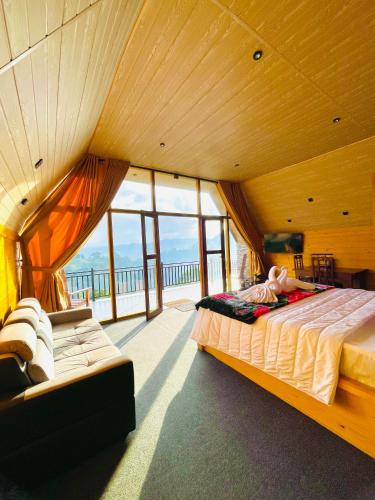 a bedroom with a large bed in a room with windows at Paddy Breeze Cabana Ella in Ella