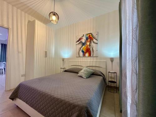 a bedroom with a bed and a painting on the wall at Wedgewood - The XL Suite in Sliema