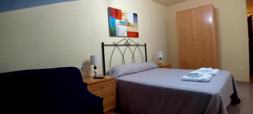 a bedroom with a bed with towels on it at Apartamento Ático Select Real Caldas de Reis in Caldas de Reis