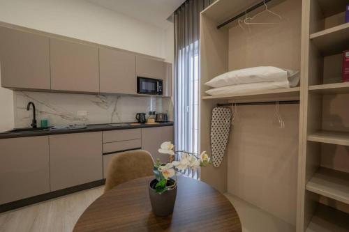 a kitchen with a wooden table with a vase of flowers at Urban Vibe 3 in Kirkop