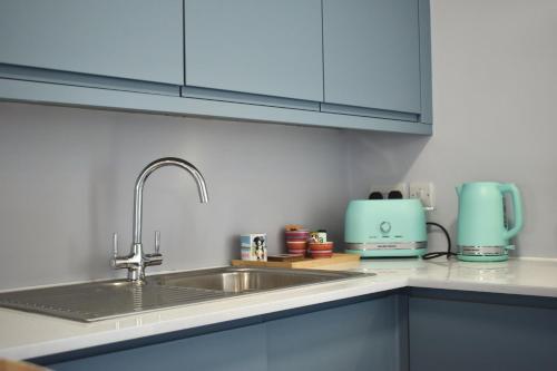 a kitchen with a sink and a blue appliance at Sunday Cottage in St. Just