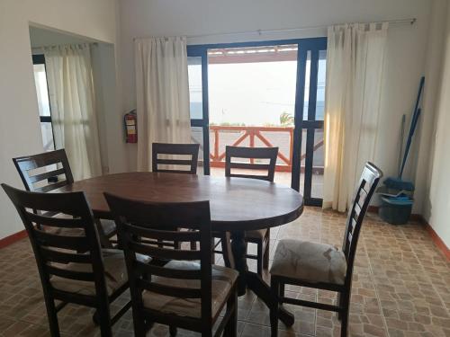 a dining room with a wooden table and chairs at Casuarinas Del Mar Hospedaje Chalet 3 habitaciones in Canoas