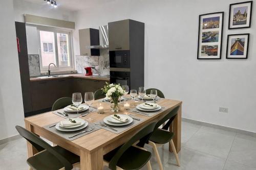 a dining room table with plates and wine glasses at 3-Bedroom with Jacuzzi & Private Terrace in Is-Swieqi