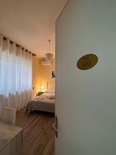a room with a bed and a door with a clock on it at Giardino dei Baroni house in Marina di Mancaversa