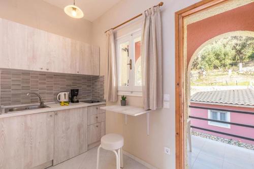 a kitchen with a sink and a window at Galini Seaview Kontogialos in Pelekas