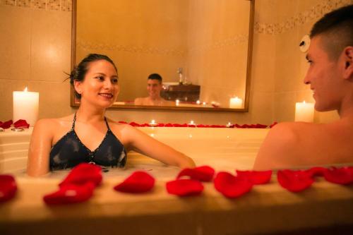a man and a woman in a bathtub with red roses at Sangay Spa Hotel in Baños