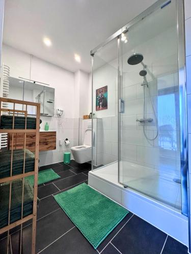 a bathroom with a shower and two green rugs at Weserblick Hafen-Villa-Bremen in Bremen