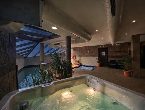 a large bath tub in a room with a swimming pool at Apartamentos Spa Casco Histórico de Isla in Isla