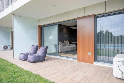 a house with two purple chairs on a patio at Liiiving in Porto - Dragão Pool View in Porto