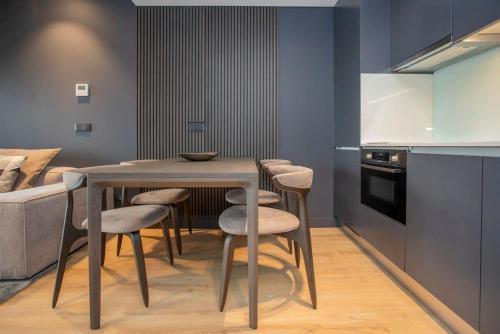 a kitchen with a table and chairs in a room at Liiiving in Porto - Dragão Pool View in Porto