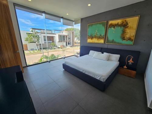 a bedroom with a bed and a large window at Torres Mittah Oceanview Condos at La Cruz de Huanacaxtle in Cruz de Huanacaxtle
