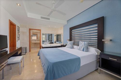 a bedroom with a large bed with a blue wall at Anfi del Mar Tauro Golf 1 Emerald Club in Mogán