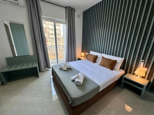 a bedroom with a large bed with towels on it at Large 3-Bedroom with Jacuzzi near St Julians in Is-Swieqi