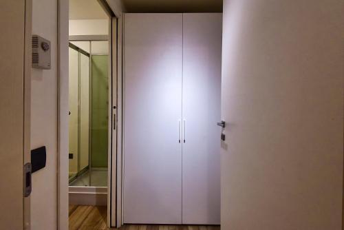 ein weißer Schrank in einem Raum mit einem Spiegel in der Unterkunft Casa Pintea in Legnano