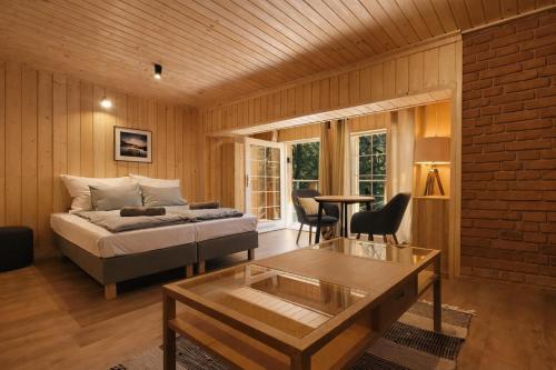 a bedroom with a bed and a coffee table in a room at Apartamenty Leśna Przystań nad jeziorem in Węgorzewo